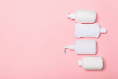 Beyaz Kozmetik kapları seti pembe arka plan üzerinde izole, kopya alanı ile üst görünümü. Tasarım için boş alana sahip plastik vücut bakım şişe kapları Grubu