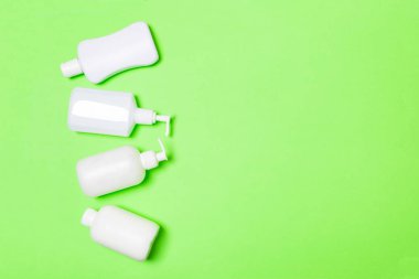 Beyaz Kozmetik kapları yeşil arka plan üzerinde izole seti, kopya alanı ile üst görünümü. Tasarım için boş alana sahip plastik vücut bakım şişe kapları Grubu