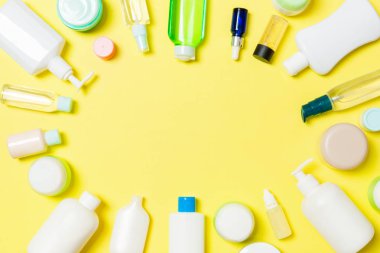 Plastik gövde bakımı şişesinin çerçevesi düz kompozisyon ve kozmetik ürünlerle birlikte tasarladığınız boş arkaplan boşluğunda duruyordu. Beyaz Kozmetik kapları kümesi, kopya alanı ile üst görünüm