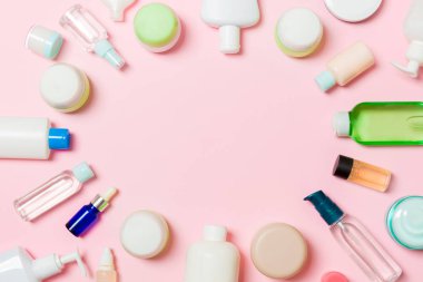 Çerçeve plastik vücut bakım şişesi Düz tasarım için pembe arka plan boş alan kozmetik ürünleri ile kompozisyon yatıyordu. Beyaz Kozmetik kapları seti, fotokopi alanı ile üst görünüm