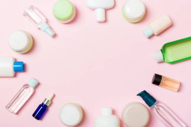 Çerçeve plastik vücut bakım şişesi Düz tasarım için pembe arka plan boş alan kozmetik ürünleri ile kompozisyon yatıyordu. Beyaz Kozmetik kapları seti, fotokopi alanı ile üst görünüm