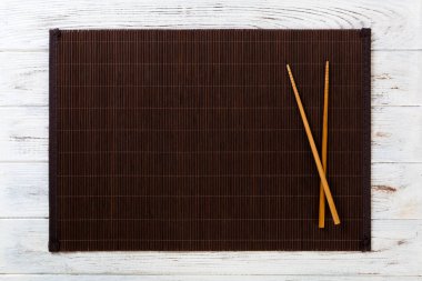 kopya alanı ile beyaz ahşap Arka Plan Üst görünümü nde boş bambu paspas veya ahşap plaka ile iki suşi çubukları. boş asya gıda arka plan