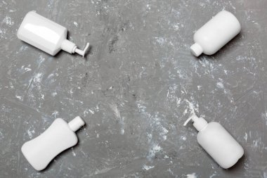 Sarı arka planda izole beyaz Kozmetik Konteynerler seti, kopya alanı ile üst görünüm. Size tasarım için boş alan ile plastik vücut bakımı şişe kapları grubu