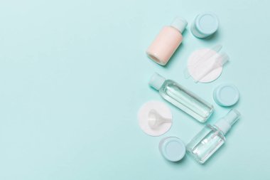 Mavi arka planda seyahat için küçük şişe grubu. Fikirlerinize yer kopyalayın. Kozmetik ürünlerin düz yatıyordu bileşimi. Pamuk pedleri ile krem konteynerlerin üst görünümü