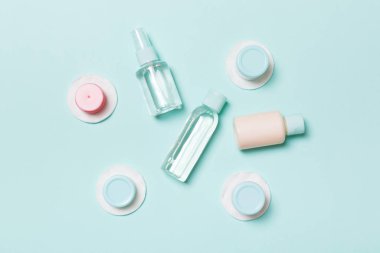 Mavi arka planda seyahat için küçük şişe grubu. Fikirlerinize yer kopyalayın. Kozmetik ürünlerin düz yatıyordu bileşimi. Pamuk pedleri ile krem konteynerlerin üst görünümü