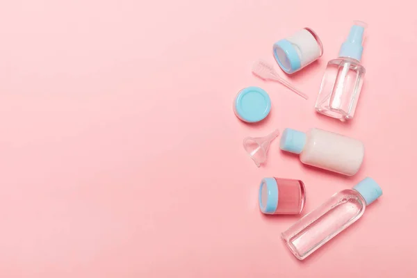 A kozmetikai termékek számára szánt kisméretű üvegpalackok és üvegedények felülnézete a rózsaszínű háttérrel. Arc bőrápolási koncepció, másolási helyet a design — Stock Fotó