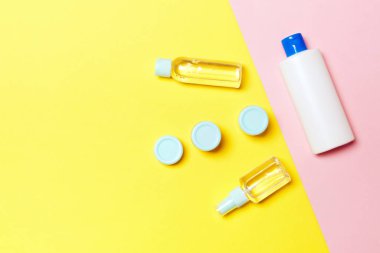 Plastik vücut bakımı şişesi grubu düz size tasarım için sarı ve pembe arka plan boş alan kozmetik ürünleri ile kompozisyon yatıyordu. Beyaz Kozmetik Konteynerler, kopya alanı ile üst görünüm seti