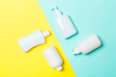 Beyaz Kozmetik kaplar seti sarı ve mavi arka planda izole edilmiş, fotokopi alanı olan üst manzara. Senin için bir grup plastik kaplar ve boş bir yer tasarladın.