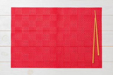 boş kırmızı masa örtüsü ile iki suşi Chopsticks, Beyaz ahşap arka plan üst görünümünde kopya alanı ile peçete. Asya gıda arka plan boş