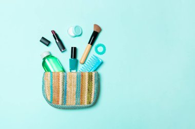 Tasarım için boş alan ile Mavi Pastel arka plan üzerinde kozmetik çanta dışarı dökülme ürünleri makyaj
