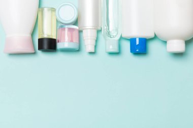 Mavi arka planda kozmetik şişeleri üst görünümü. Tasarım için alan ile cilt bakımı kavramı