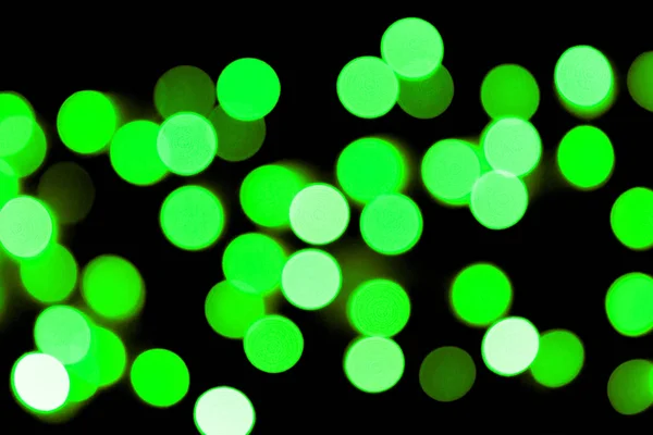 초점을 맞추지 않은 추상적 인 다채로운 보케 블랙 배경입니다. 초점이 맞지 않고 많은 둥근 녹색 표시등이 흐려집니다. — 스톡 사진
