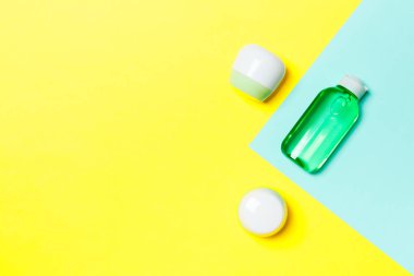 Plastik vücut bakımı şişesi grubu düz size tasarım için sarı ve mavi arka plan boş alan kozmetik ürünleri ile kompozisyon yatıyordu. Beyaz Kozmetik Konteynerler, kopya alanı ile üst görünüm seti