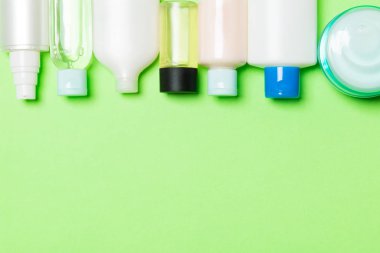 Yeşil arka plan üzerinde krem ve kozmetik şişe ve kavanoz seti. Tasarımınız için boş alana sahip Bodycare konsepti