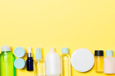Sarı arka plan üzerinde krem ve kozmetik şişe ve kavanoz seti. Tasarımınız için boş alana sahip Bodycare konsepti