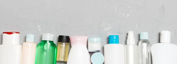 Composición plana con botellas cosméticas y de crema sobre fondo de cemento. Concepto de productos de belleza con espacio de copia —  Fotos de Stock