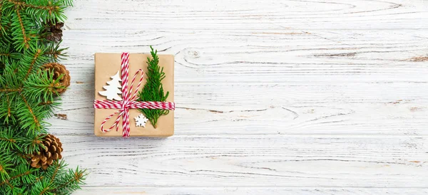 De doos van de gift van Kerstmis verpakt in gerecycled papier, met lint Bow, met lint op rustieke achtergrond. Vakantie banner concept — Stockfoto