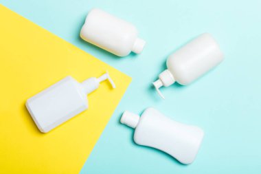 Beyaz Kozmetik kaplar seti sarı ve mavi arka planda izole edilmiş, fotokopi alanı olan üst manzara. Senin için bir grup plastik kaplar ve boş bir yer tasarladın.