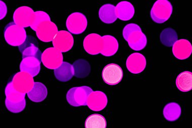 Siyah arka plan üzerinde odaklanmamış soyut mor bokeh. deffocused ve bulanık birçok yuvarlak ışık