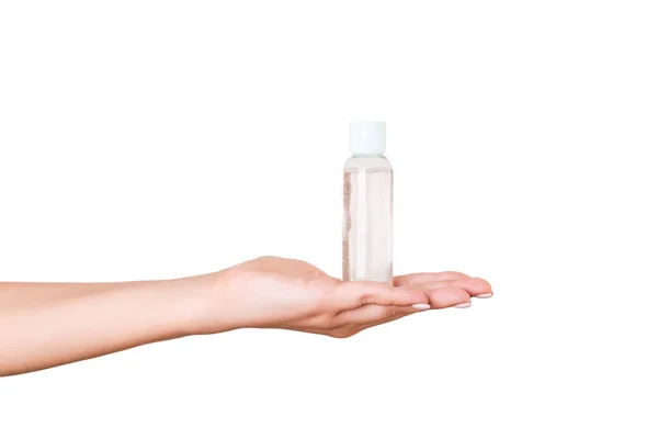 Mão feminina segurando creme garrafa de loção isolada. Menina dar produtos cosméticos tubo no fundo branco — Fotografia de Stock