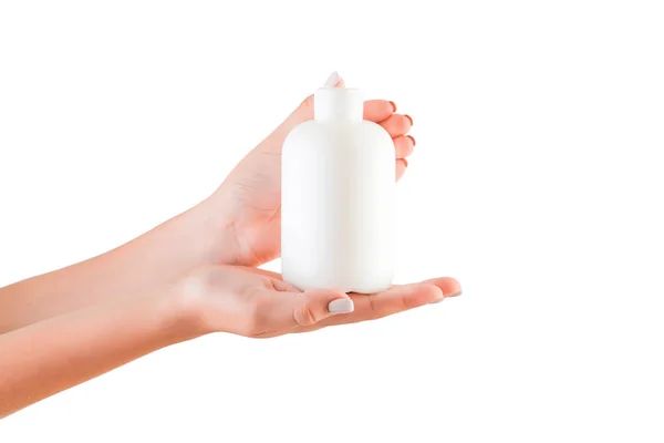 Kvinnlig hand hållande grädde flaska av lotion isolerad. Flicka ge röret kosmetiska produkter på vit bakgrund — Stockfoto