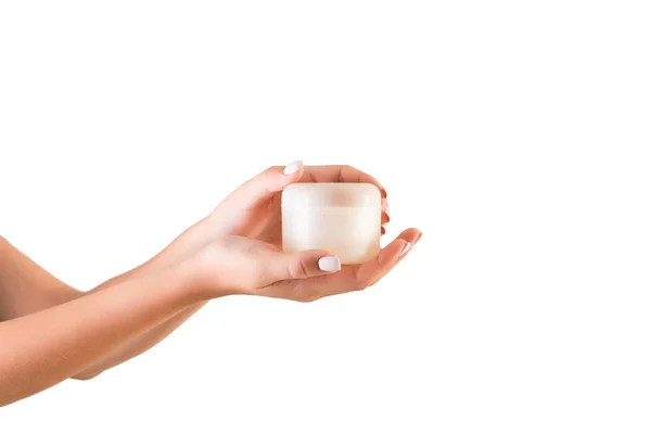 Vrouwelijke hand houden crème fles van lotion geïsoleerd. Meisje geven jar cosmetische producten op witte achtergrond — Stockfoto