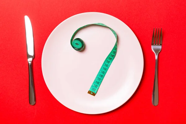 Fork and plate with measuring tape on color background. Diet concept — Stock Photo, Image