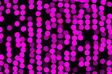 Siyah arka plan üzerinde odaklanmamış soyut mor bokeh. deffocused ve bulanık birçok yuvarlak ışık