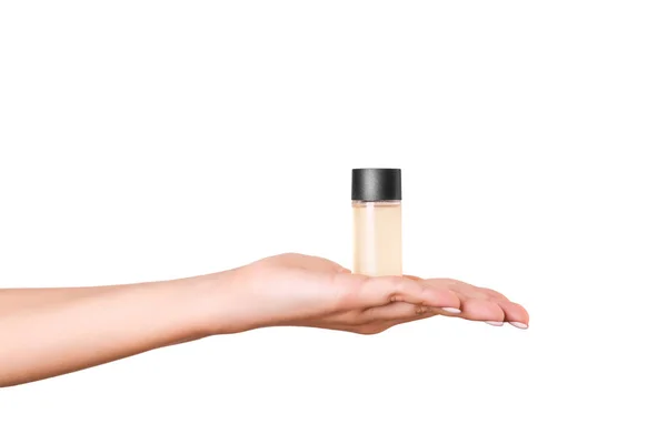 Mão feminina segurando creme garrafa de loção isolada. Menina dar jar produtos cosméticos no fundo branco — Fotografia de Stock