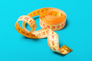 Mavi arka plan üzerinde karışık ölçüm bandı yakın. Perspektif görünümü ile fitness ve sağlıklı beslenme concep