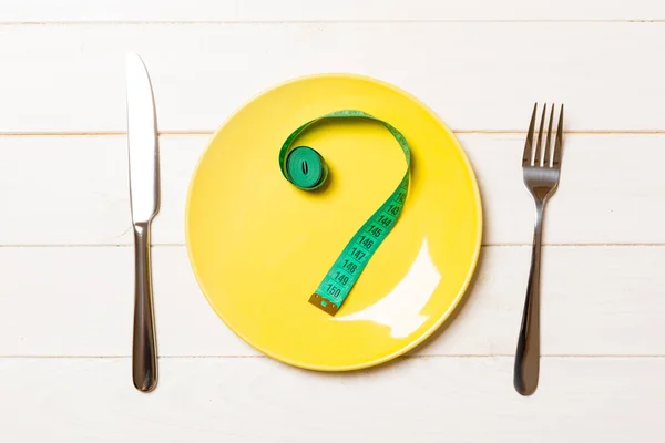 Fork and plate with measuring tape on color background. Diet concept — Stock Photo, Image