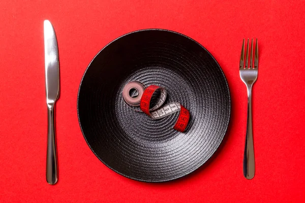 빨간색 배경에 측정 테이프, 포크와 칼 접시의 건강한 다이어트 개념. 맨 위 보기 — 스톡 사진