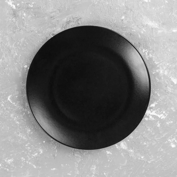 회색 시멘트 배경, 상단보기, 복사 공간에 검은 색 원형 플레이트 — 스톡 사진