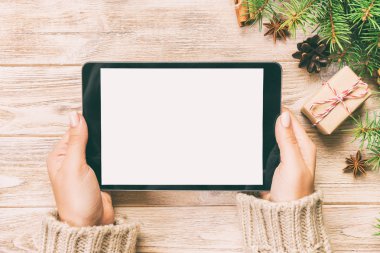 ahşap masa bachground üzerinde tablet bilgisayar kullanarak kadın eller. cristmas alışveriş zamanı. Mutlu Noeller arka plan kadar alay, üst görünümü. Tonda