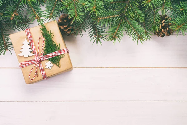圣诞背景圣诞礼物与杉枝和松果在木制白色背景与复制空间平躺，顶视图。色调 — 图库照片