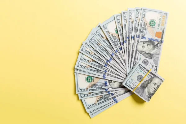 Yüz dolarlık fan yakın, renkli arka plan üzerinde iş kavramının üst görünümü