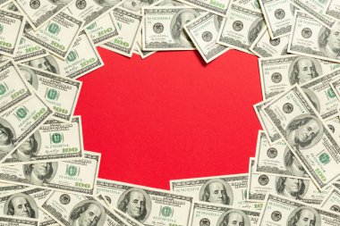 Ortasında fotokopi alanı olan dolardan yapılmış bir çerçeve. Kırmızı arkaplanda fotokopi alanı ile iş dünyasının üst görünümü