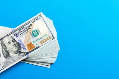 Renkli bir geçmişi olan 100 dolarlık banknotlar. Tasarımınız için boş alanı olan finansal konseptin üst görünümü