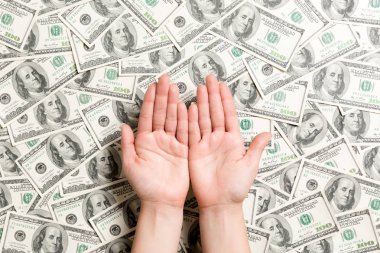 Dolar arka planda kadın elleri üst görünümü. Tasarım için boş alan ile zenginlik kavramı. Dilencilik para kavramı