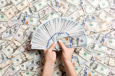 Kadın ellerinin farklı dolar arkaplanındaki paraları sayması. Borç konsepti. Yatırım kavramı