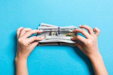 Para sayan kadın ellerinin en iyi görünümü. Renkli arka planda 100 dolarlık banknotlar. Maaş kavramı. Rüşvet kavramı
