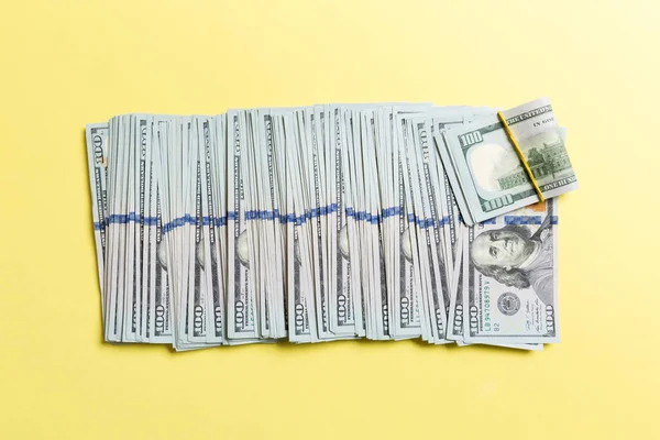 Nejlepší pohled na lhaní 100 dolarových bankovek v jednom řádku na barevném pozadí. Uzavření konceptu spoření peněz — Stock fotografie