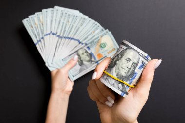 Renkli arka planda para fan tutarak kadın el üst görünümü. 100 dolarlık banknotlar. Kredi ve borç kavramı