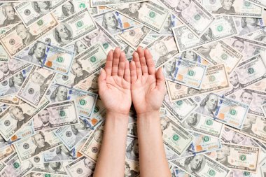 Çeşitli dolar arkaplanındaki kadın eli manzarası. Tasarımınız için boş alanı olan zenginlik kavramı. Para dilenmek.