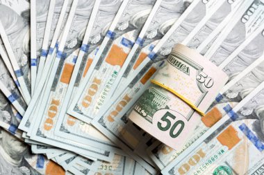 Arka planda yüz dolarlık banknotlarla yapılmış 50 dolarlık banknotların üst görüntüsü. İş konsepti