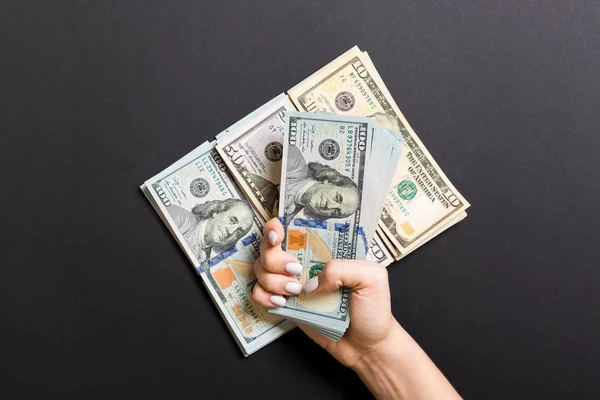 Mano femenina acostada en una pila de billetes de varios dólares sobre un fondo colorido. Ahorro de dinero y concepto de bienestar — Foto de Stock