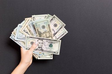 Renkli arka planda farklı dolar tutan kadın el üst görünümü. Kredi konsepti. Refah kavramı