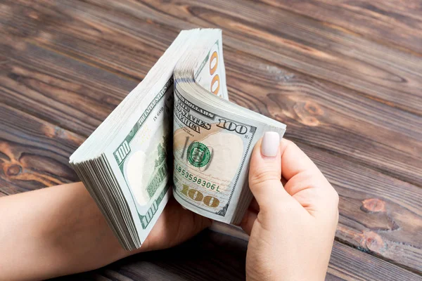 Perspektivní pohled na majitele obchodné ženy počítání 100 dolarových bankovek na dřevěném pozadí. Koncepce úspěchu a bohatství — Stock fotografie