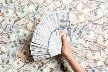 Kadın ellerinin farklı dolar arkaplanındaki paraları sayması. Borç konsepti. Yatırım kavramı