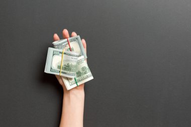 Renkli arka planda kadın palmiye tüpleri dolar banknotları rulo üst görünümü. Tasarım için boş alan ile yoksulluk ve borç kavramı